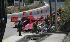 Des soldats se tiennent près des restes d'un péage en construction détruit par une explosion à Santander de Quilichao, en Colombie, le 8 août 2026 ( AFP / Joaquin SARMIENTO )