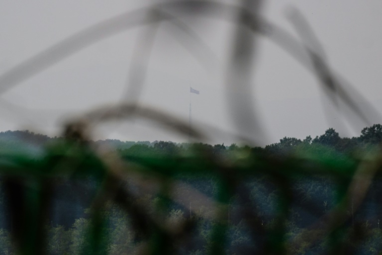 Un drapeau nord-coréen au sommet d'un mat de 160 mètres de haut flotte de l'autre côté de la frontière, vu depuis le village sud-coréen de Tongilchon, le 28 mai 2025 ( AFP / ANTHONY WALLACE )