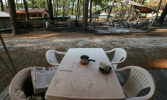Une table en plastique et du matériel de camping calciné au camping "Le Grand Crohot Ocean", à Lège-Cap-Ferret, en Gironde, le 27 juillet 2026 ( AFP / Alain JOCARD )
