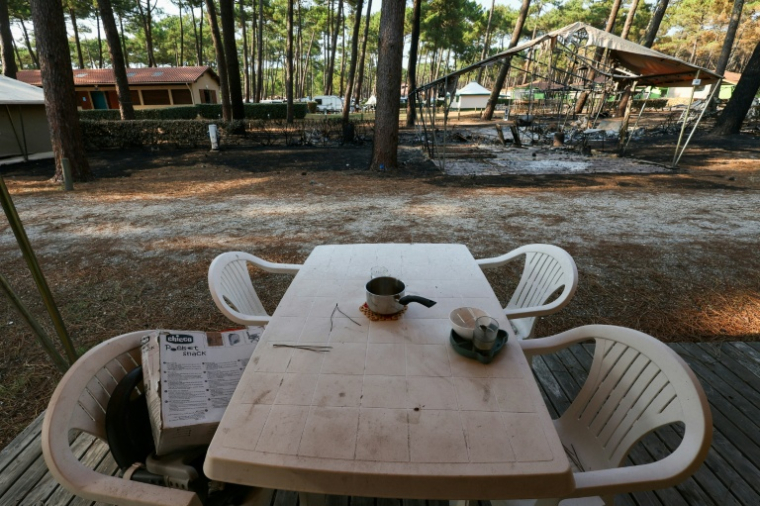 Une table en plastique et du matériel de camping calciné au camping "Le Grand Crohot Ocean", à Lège-Cap-Ferret, en Gironde, le 27 juillet 2026 ( AFP / Alain JOCARD )
