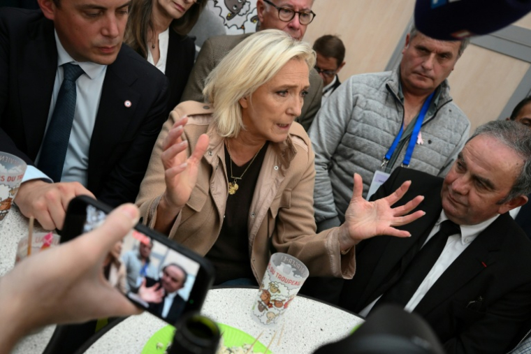 La présidente du groupe parlementaire du Rassemblement national (RN), Marine Le Pen (c), s'adresse aux médias en marge d'une visite au sommet de l'élevage à Cournon-d'Auvergne, près de Clermont-Ferrand, le 8 octobre 2025 dans le Puy-de-Dôme ( AFP / JEAN-PHILIPPE KSIAZEK )