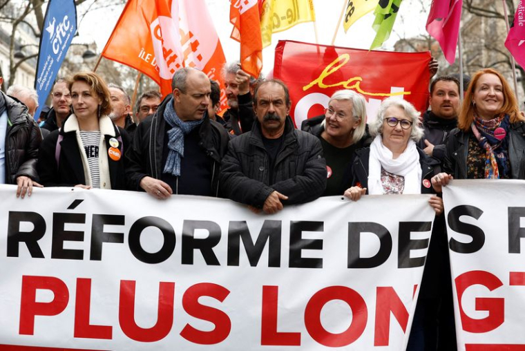 Des dirigeants syndicaux tiennent une banderole lors d'une manifestation