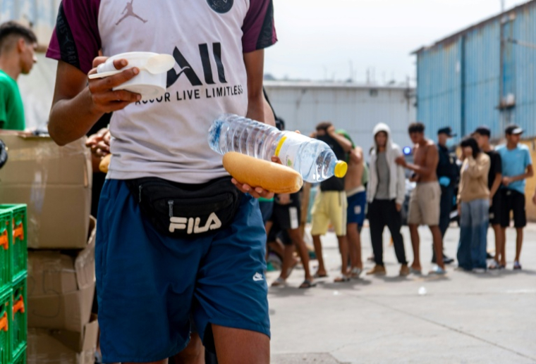 Des bénévoles de l'ONG Luna Blanca distribuent de la nourriture à des migrants sur le site industriel d'El Tajaral à Ceutae, Espagne, le 2 septembre 2026 ( AFP / Antonio Sempere )