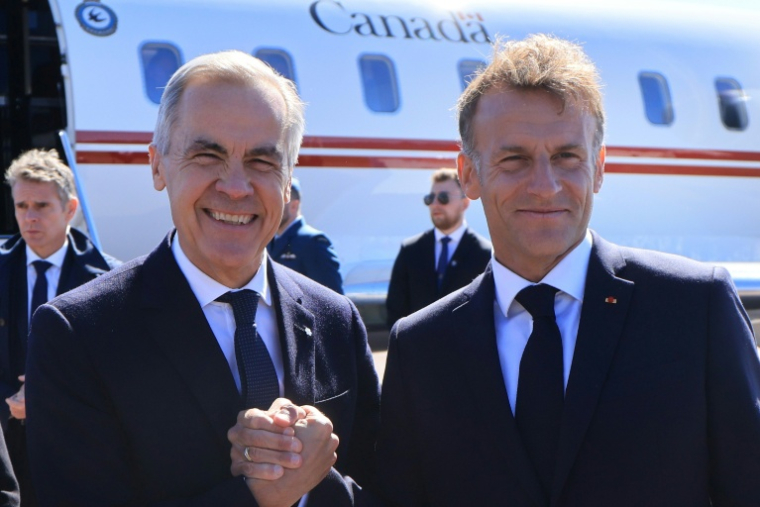 Le Premier ministre canadien Mark Carney (g) accueilli le 20 septembre 2026 par le président français Emmanuel Macron à Saint-Pierre-et-Miquelon ( AFP / Ludovic MARIN )