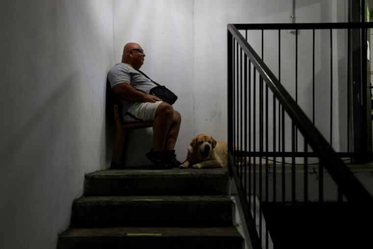 Un homme et son chien dans un abri souterrain à Haïfa, dans le nord d'Israël, après des alertes aux missiles tirés depuis l'Iran, le 23 juin 2025 ( AFP / Jalaa MAREY )