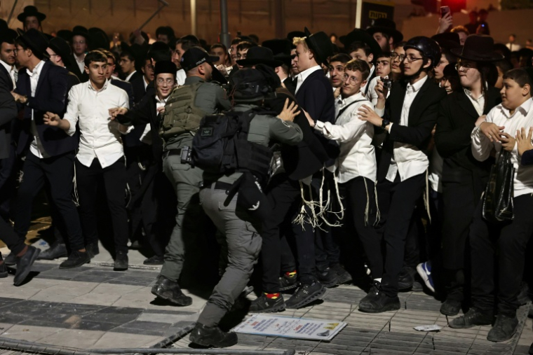 Des juifs ultra-orthodoxes rassemblés dans la rue à Jérusalem, le 30 octobre 2025, pour protester contre la conscription, dont ils sont exemptés, affrontent des policiers ( AFP / Fadel SENNA )
