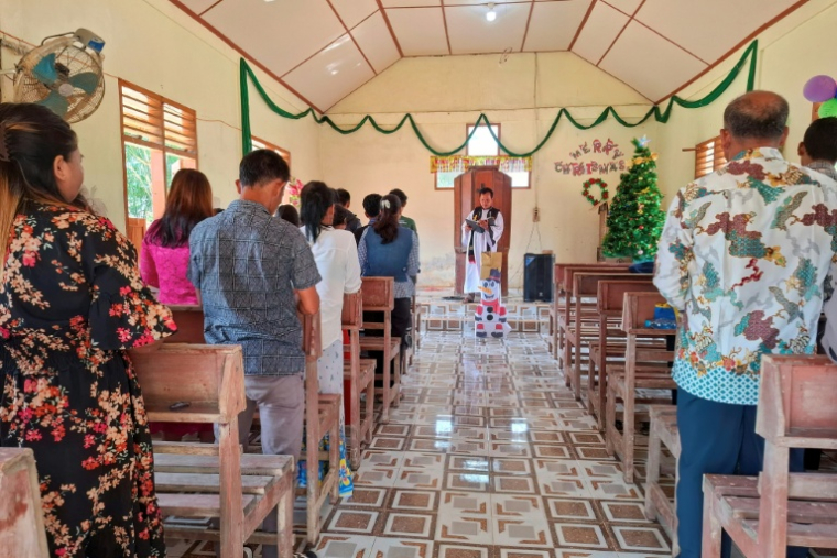 Des villageois assistent à la messe de Noël à l'église protestante d'Angkola, dans le village d'Aek Ngadol, le 25 décembre 2025, dans la province de Sumatra touchée par des inondations et glissements de terrain meurtriers, en Indonésie ( AFP / AMROE )