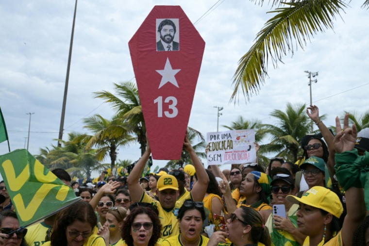 Un partisan du candidat à la présidence du Brésil Flavio Bolsonaro tient un cercueil en carton portant une photo du président Luiz Inacio Lula da Silva lors d'un rassemblement dans le quartier de Barra da Tijuca, à Rio de Janeiro, au Brésil, le 24 octobre 2026 ( AFP / TERCIO TEIXEIRA )