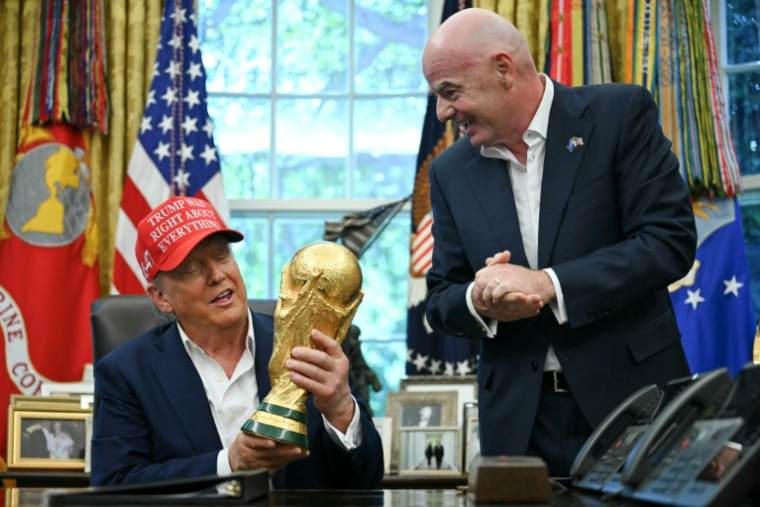 Le président américain Donald Trump et le président de la Fifa Gianni Infantino, avec le trophée de la Coupe du monde dans le bureau ovale de la Maison Blanche, le 22 août 2025 à Washington, ( AFP / ANDREW CABALLERO-REYNOLDS )