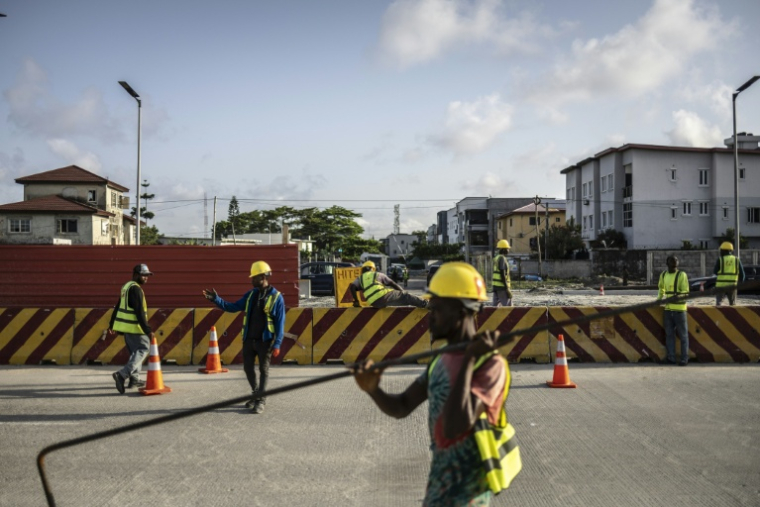 Un ouvrier du bâtiment transporte des matériaux sur un tronçon de l'autoroute côtière Lagos-Calabar, en cours de construction à Lagos, le 17 avril 2026. ( AFP / OLYMPIA DE MAISMONT )