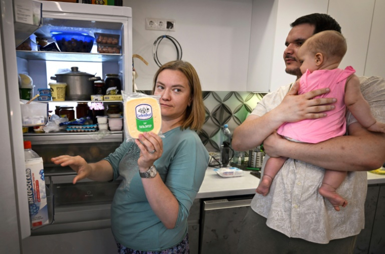 Maria Tiabout (G) montre son réfrigérateur de marque chinoise dans son appartement de Mytichtchi, une ville de 300.000 habitants au nord-est de Moscou, le 17 juin 2025 ( AFP / Alexander NEMENOV )