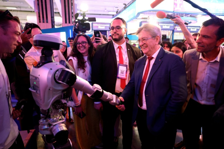 Le leader de La France insoumise (LFI), Jean-Luc Mélenchon, serre la main d'un robot humanoïde lors de sa visite au salon VivaTech, le 19 juin 2026 à Paris ( AFP / SIMON WOHLFAHRT )