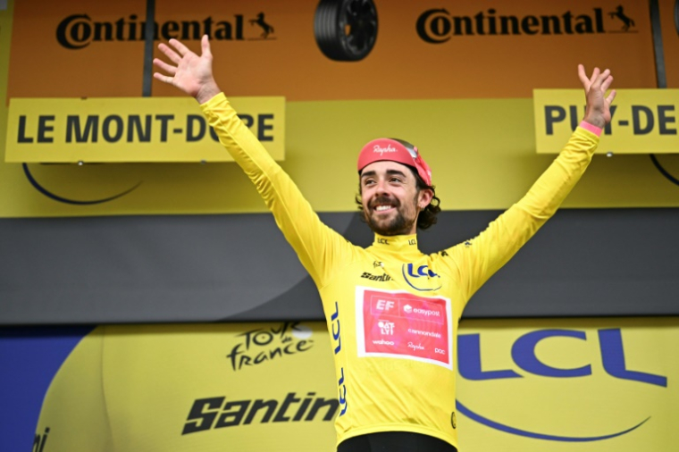 L'Irlandais Ben Healy sur le podium avec le maillot jaune, au Mont-Dore, le 14 juillet 2025 ( AFP / Loic VENANCE )
