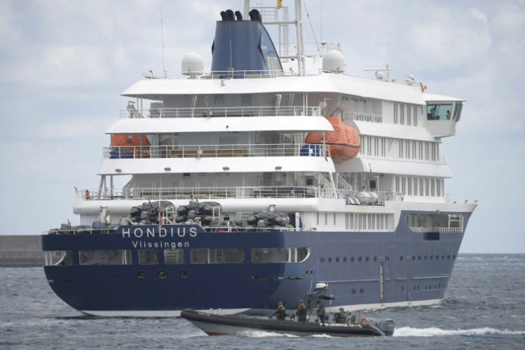 Un bateau de la Guardia Civil espagnole navigue à côté du bateau de croisière MV Hondius, touché par le hantavirus, dans le port de Granadilla de Abona, sur l'île de Tenerife, dans l'archipel espagnol des Canaries, le 11mai 2026 ( AFP / JORGE GUERRERO )