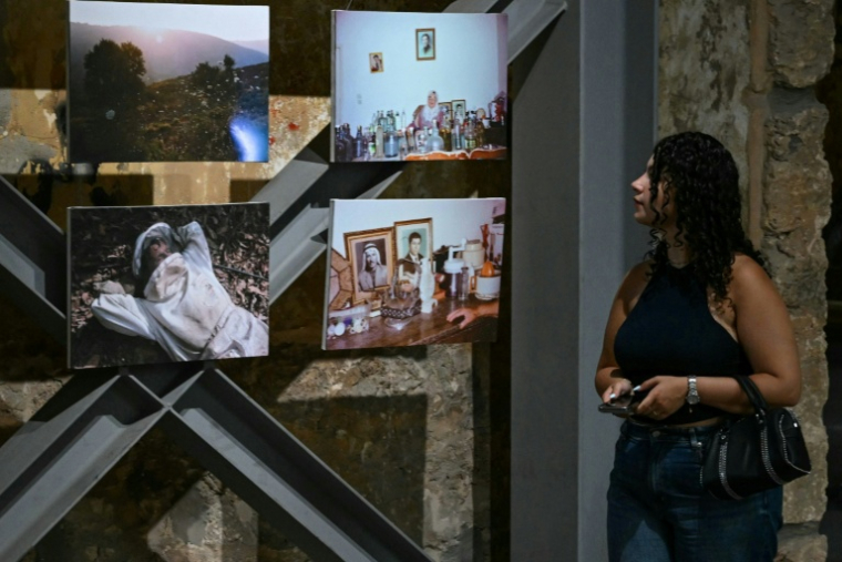 Une visiteuse de l'exposition "Hkeeli ya Jnoub" (Dis-moi, Ô Sud), qui vise à préserver la mémoire des villages détruits par Israël dans le sud du Liban, le 17 juillet 2026 à Beyrouth ( AFP / JOSEPH EID )