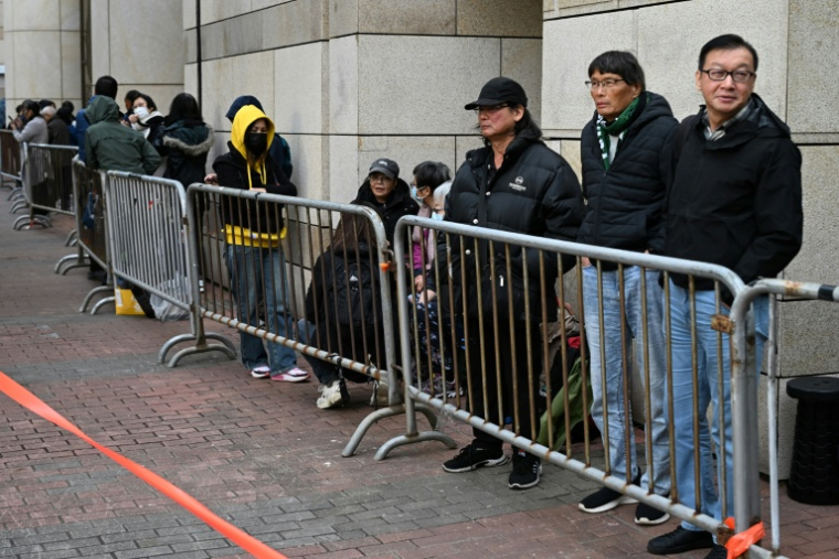 Des personnes attendent devant le tribunal de West Kowloon avant les débats sur la peine à infliger à l'ex-magnat des médias prodémocratie Jimmy Lai, le 12 janvier 2026 à Hong Kong ( AFP / Peter PARKS )
