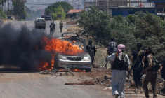 Des combattants bédouins et tribaux se déploient alors qu’une voiture est en feu à l’entrée ouest du bastion druze de Soueïda, dans le sud de la Syrie, le 18 juillet 2025 ( AFP / Bakr ALKASEM )