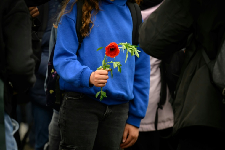 Une élève du collège Libertaire Rutigliano tient une fleur en hommage à l'adolescent de 15 ans tué lors d'une fusillade, le 18 mai 2026 à Nantes ( AFP / Loic VENANCE )