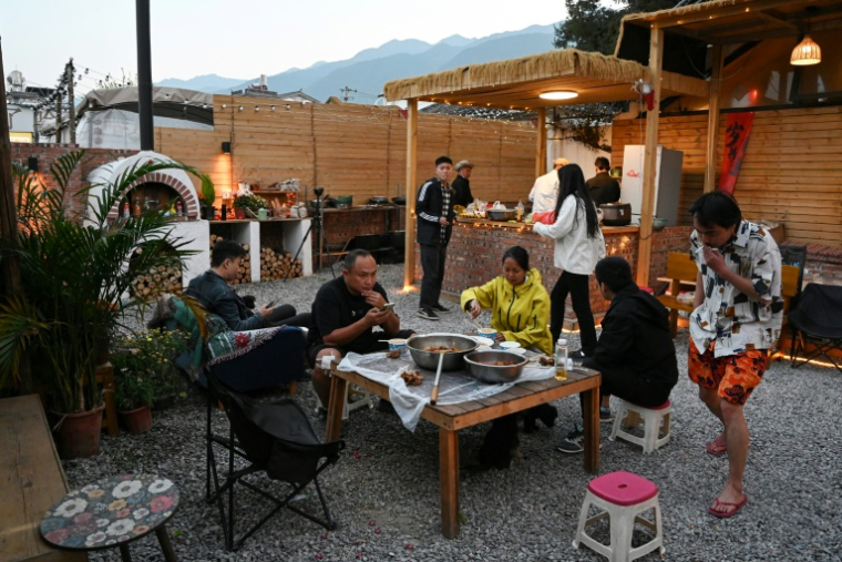 Des Chinois partagent un repas dans une "maison de retraite pour jeunes" à Dali, dans la province du Yunnan, dans le sud-ouest de la Chine, le 2 avril 2025 ( AFP / GREG BAKER )