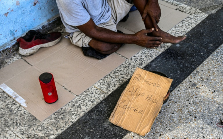 Un homme mendie dans une rue de La Havane, le 21 juillet 2025 à Cuba ( AFP / Yamil LAGE )