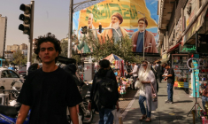 Des passants devant un panneau d'affichage représentant les dirigeants libanais du Hezbollah assassinés Hassan Nasrallah (C) et son successeur Hachem Safieddine (D), ainsi que le général iranien Qassem Soleimani, à Téhéran, le 28 septembre 2025 ( AFP / ATTA KENARE )