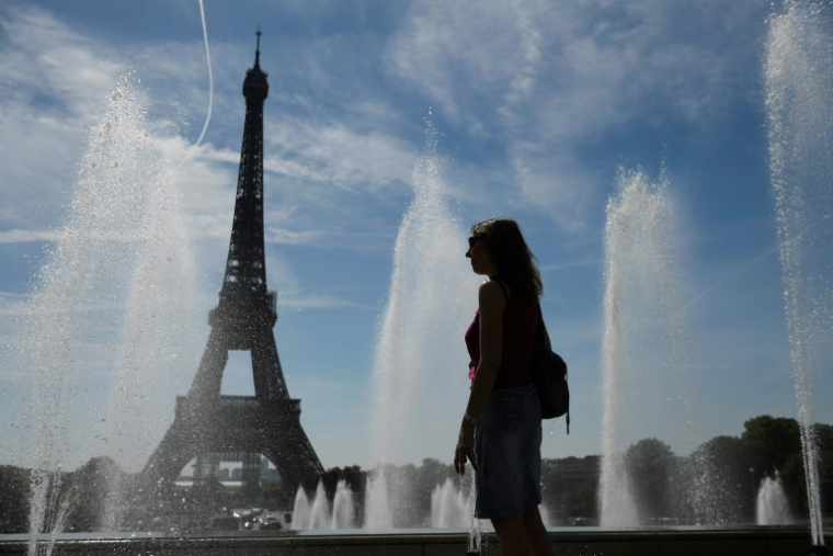Une femme se rafraîchit près des fontaines du Trocadéro, lors de températures élevées à Paris, le 16 juin 2022 ( AFP / JULIEN DE ROSA )