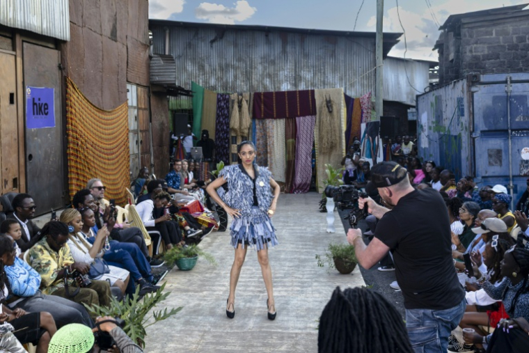 Des mannequins présentent des tenues de créateurs locaux spécialisés dans le recyclage de tissus et de vêtements mis au rebut, lors du défilé de mode Gikomba Runway Edition à Nairobi, le 10 octobre 2025 au Kenya ( AFP / Tony KARUMBA )