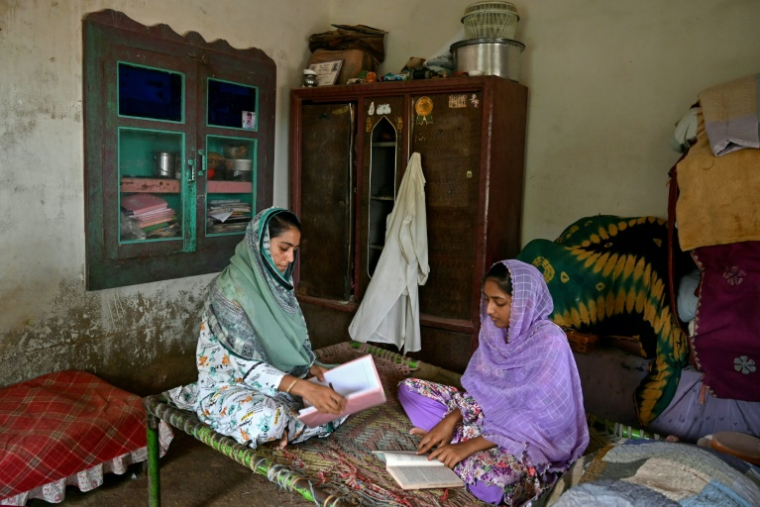 Durga Prem (g), étudiante en ingénierie informatique et sa soeur Mumta, chez elle à Badin, dans la province du Sindh, le 15 juillet 2025 au Pakistan ( AFP / Asif HASSAN )