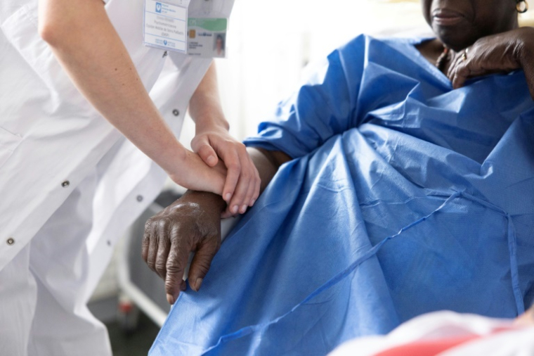Une psychomotricienne du service mobile de soins palliatifs au chevet d'une patiente de l'hôpital Antoine-Béclère de l'AP-HP, à Clamart le 27 mai 2025 ( AFP / Thomas SAMSON )