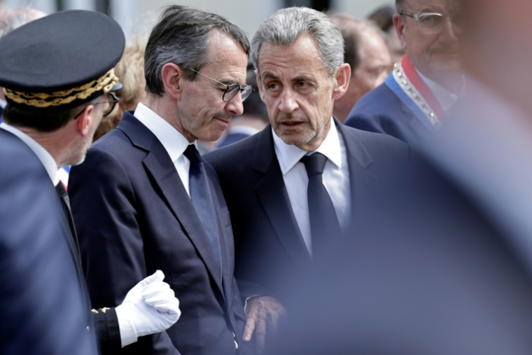 L'ancien président Nicolas Sarkozy (C) discute avec le ministre de l'Intérieur Bruno Retailleau (2e G) lors d'un hommage à Aurélie Fouquet, policière municipale tuée en 2010, le 20 mai 2025 à Villiers-sur-Marne, dans le Val-de-Marne ( AFP / STEPHANE DE SAKUTIN )