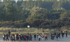Des migrants courent sur la plage pour tenter d'embarquer à bord d'un "taxi-boat" pour traverser la Manche, le 11 août 2025 à Gravelines, dans le Nord ( AFP / Sameer Al-DOUMY )