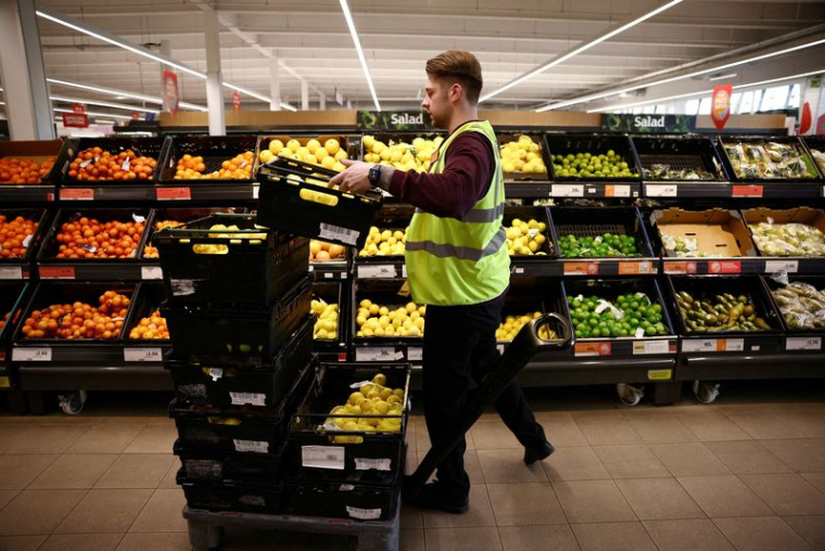 Un employé range des produits dans un supermarché Sainsbury's à Richmond, dans l'ouest de Londres