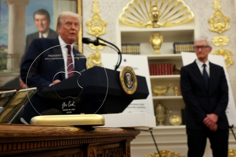 In August, Apple CEO Tim Cook presented President Donald Trump with an engraved glass disc; the company is reportedly considering an investment in Intel, in which the US government holds an equity stake  ( GETTY IMAGES NORTH AMERICA / WIN MCNAMEE )