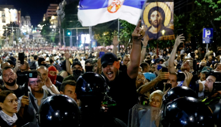 Des policiers anti-émeutes face à des manifestants hostiles au gouvernement à Belgrade le 15 août 2025  ( AFP / Marko Djokovic )