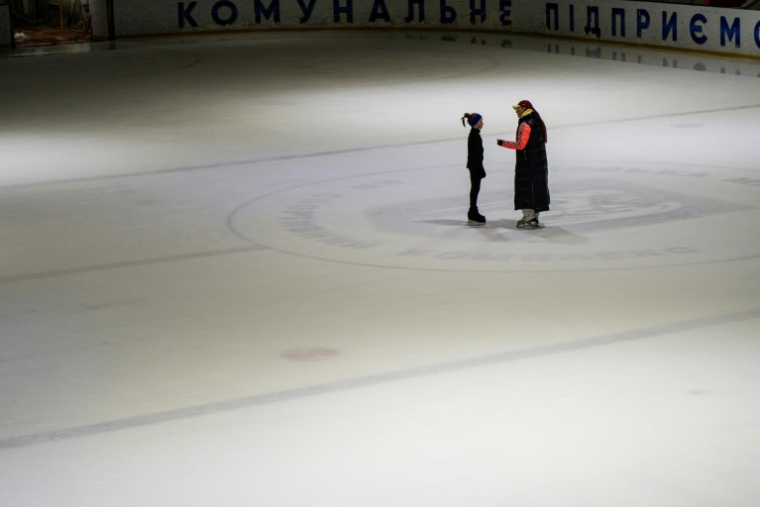 Une entraîneuse ukrainienne échange avec une jeune patineuse sur une patinoire à Kiev, le 16 octobre 2026 ( AFP / Genya SAVILOV )