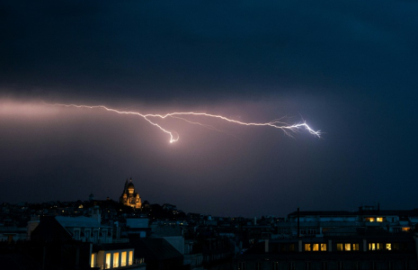 Un éclair dans un ciel d'orage près de la basilique du Sacré Coeur à Montmartre, le 25 juin 2025 à Paris ( AFP / Julie SEBADELHA )