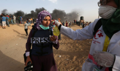 Une photojournaliste est traitée contre les gaz lacrymogènes lors d'une manifestation à la frontière entre Israël et la bande de Gaza, dans le sud de la bande de Gaza