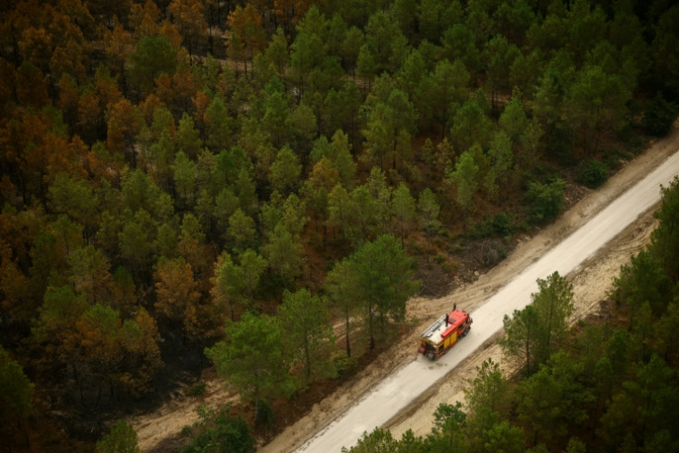 Vue aérienne depuis un hélicoptère de la sécurité civile montrant un camion de pompiers sur une route à Le Porge, en Gironde, le 31 juillet 2026 ( POOL / Sarah Meyssonnier )