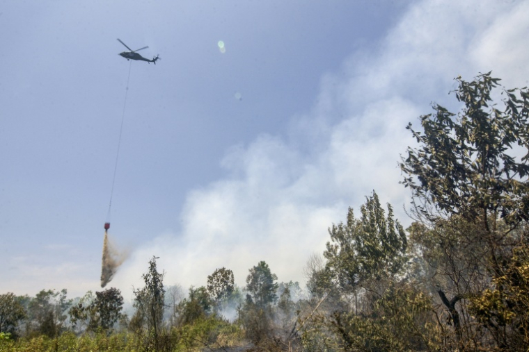 Un hélicoptère largue de l’eau sur des forêts et des terres en feu dans les zones de Tegal Arum et Guntung Damar, à Banjarbaru, dans la province de Kalimantan du Sud, en Indonésie, le 19 septembre 2026 ( AFP / MUDA SAGALA )