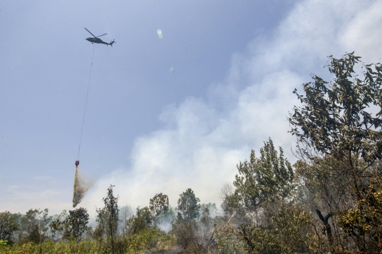 Un hélicoptère largue de l’eau sur des forêts et des terres en feu dans les zones de Tegal Arum et Guntung Damar, à Banjarbaru, dans la province de Kalimantan du Sud, en Indonésie, le 19 septembre 2026 ( AFP / MUDA SAGALA )
