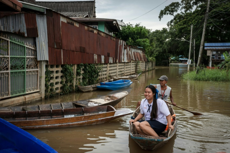 Des habitants se déplacent en barque dans leur village inondé de la province d'Ayutthaya, le 6 octobre 2026 en Thaïlande ( AFP / Chanakarn LAOSARAKHAM )
