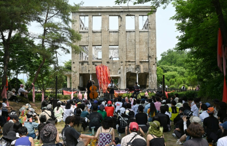 e musicien indie-pop sud-coréen "Haepa" se produit devant l'ancien siège du Parti des travailleurs de Corée du Nord lors DMZ Peace Train Festival à Cheorwon, le 14 juin 2026 en Corée du Sud, près de la frontière avec la Corée du Nord026. ( AFP / Jung Yeon-je )