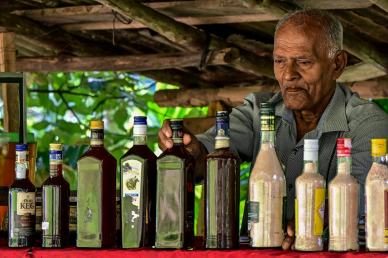 Un vendeur dispose des produits fabriqués à partir de la sève de kithul, dans le village d'Ambegoda, le 26 janvier 2026 au Sri Lanka ( AFP / Ishara S. KODIKARA )