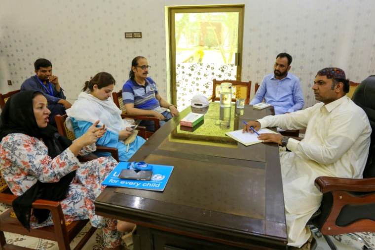 Zahida Manzoor, de l'Unicef, s'entretient avec Muhammad Azhar (d), directeur adjoint du comité municipal du district de Rajanpur, dans la province du sud-ouest du Pendjabn, le 15 mai 2025 au Pakistan ( AFP / Shahid Saeed MIRZA )