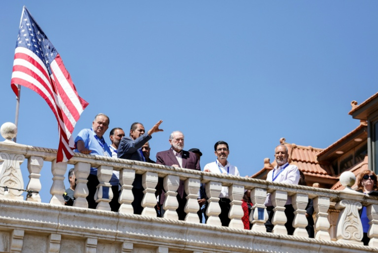 L'ambassadeur des États-Unis en Israël, Mike Huckabee (c), sur le toit de la maison d'un résident palestino-américain, harcelé par des colons israéliens, observe la colonie juive érigée près de la ville de Turmus Ayya, en Cisjordanie, le 5 septembre 2026 ( AFP / John Wessels )