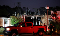 Les pompiers au travail devant l'église mormone de Grand Blanc, dans le Michigan, attaquée à l'arme à feu et incendiée par un individu le 28 septembre 2025 ( AFP / JEFF KOWALSKY )