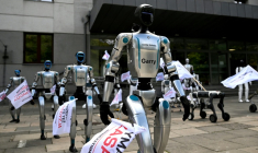 Munis de drapeaux, des robots manifestent devant le ministère polonais du Numérique, à Varsovie, pour demander l'encadrement de l'intelligence artificielle (IA) dans le monde du travail, le 7 septembre 2026 ( AFP / Sergei GAPON )