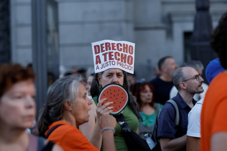 Un manifestant tient une pancarte portant l'inscription « Droit à un toit à un prix équitable » lors d'une manifestation contre les expulsions et la crise du logement sur la Puerta del Sol à Madrid, le 26 septembre 2026 ( AFP / Oscar DEL POZO )