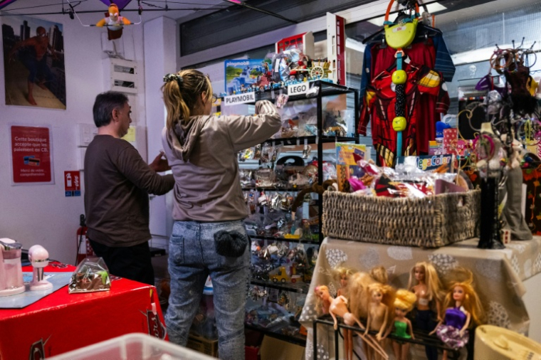 Des employés installent des jouets en rayon à La P'tite Boutique, à Chaville, dans les Hauts-de-Seine, le 7 novembre 2025 ( AFP / Julie SEBADELHA )