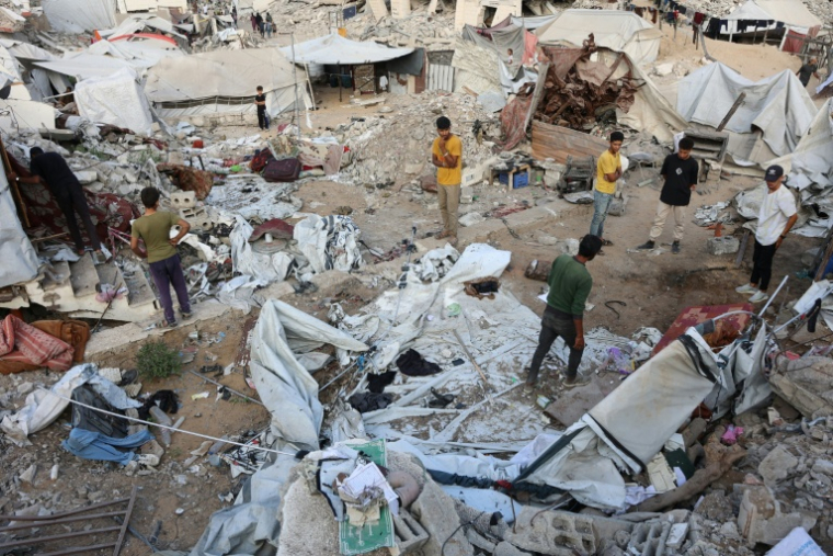 Des Palestiniens inspectent les dégâts après une frappe israélienne nocturne, dans le quartier nord d'Al-Rimal de la ville de Gaza, le 15 juillet 2025 ( AFP / Omar AL-QATTAA )